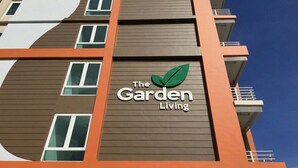 A multi-story building with a sign that reads "The Garden Living." - The Garden Living (Bangkok)