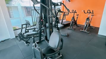 A gym with various exercise equipment, including a squat rack and treadmills.