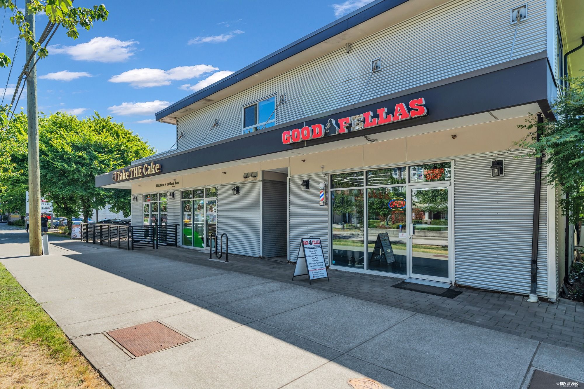 A storefront with a sign for 'GOOD FELLAS' and a sign for 'Take THE Cake' bakery.