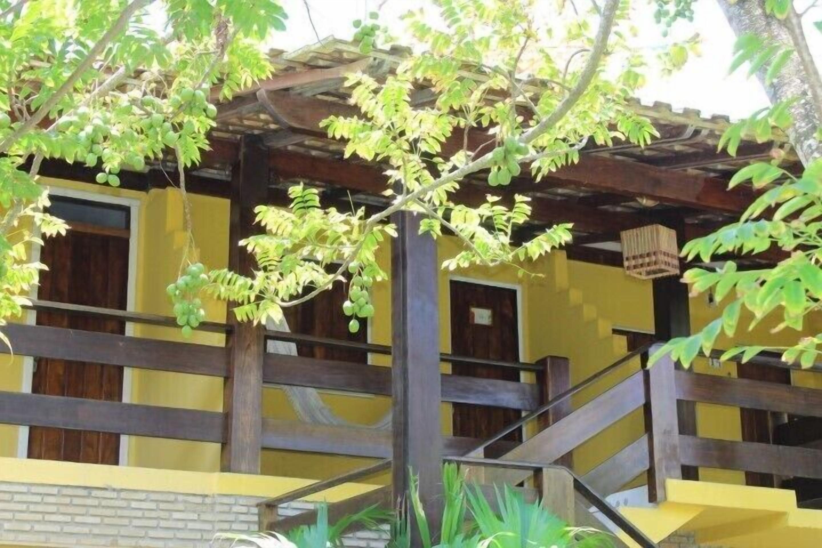 Un bâtiment à la façade jaune, doté de balcons en bois et d’un escalier.