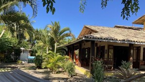 A rustic house with a tiled roof and a hammock in the foreground. - Pousada Velas e Vento - Acesso fácil a Barra Grande (Maraú)