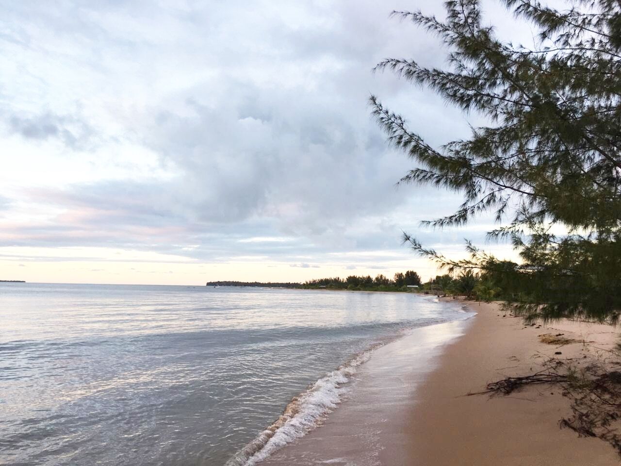 A beach with calm waters and a distant shoreline.
