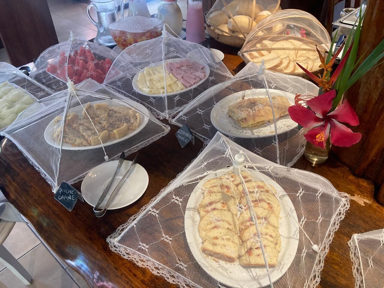 A buffet with various dishes covered in protective netting.