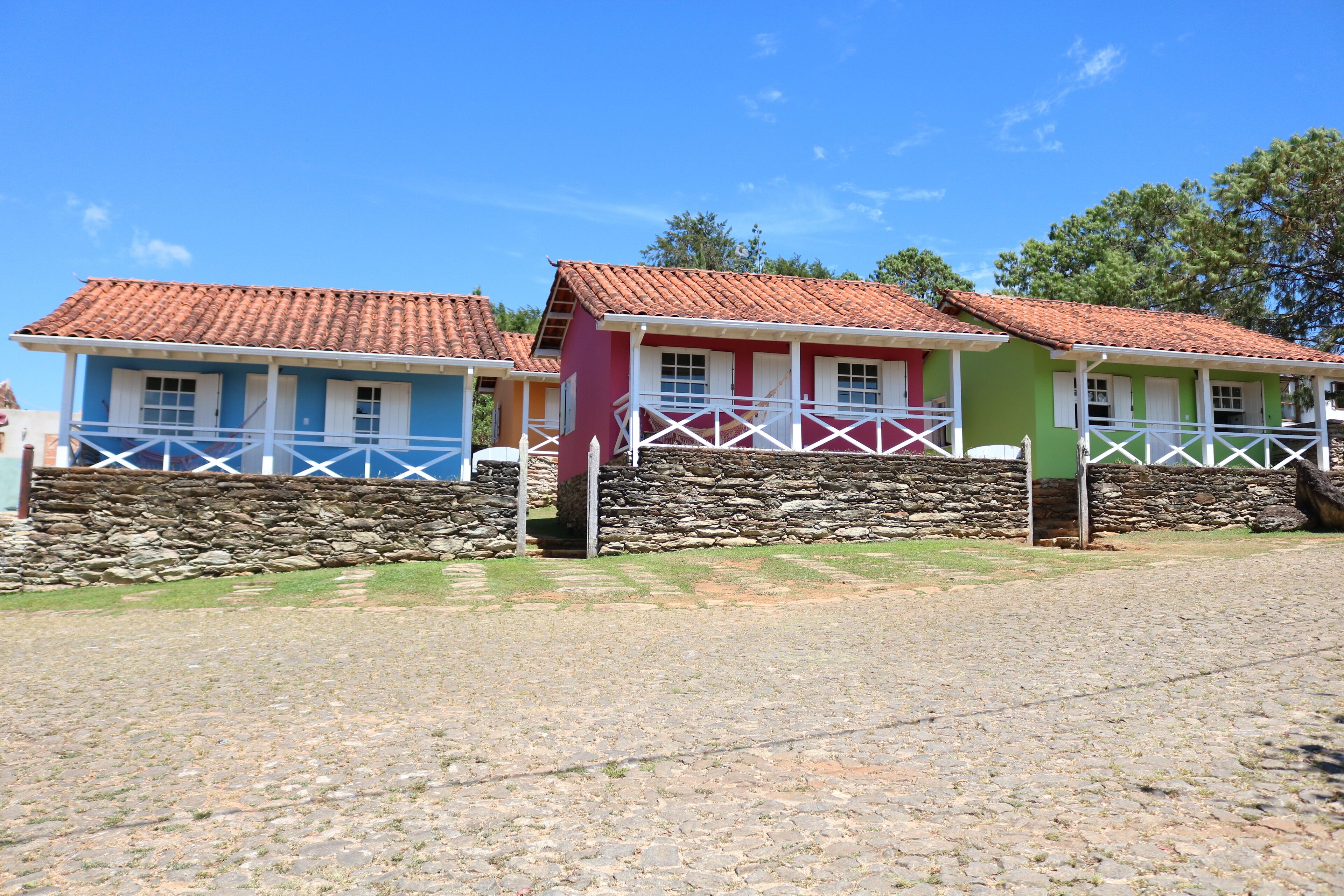 A row of colorful houses with stone walls and tiled roofs.