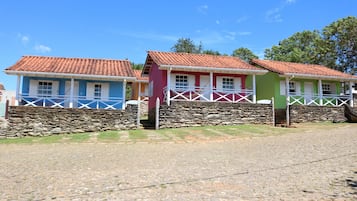 A row of colorful houses with stone walls and tiled roofs.
