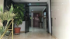 An entrance with a glass door leading to a hallway, a potted plant, and a tiled floor. - Hotel Anthony's (Lima)