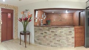 A reception area with a wooden reception desk, a no smoking sign, and a wall-mounted sign that reads "Ambroy's". - Hotel Anthony's (Lima)