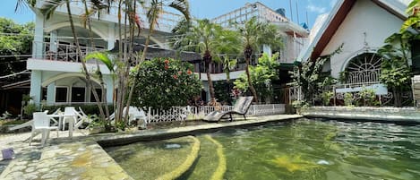 Una piscina al aire libre, sillones reclinables de piscina