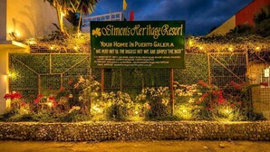 A sign for Simon's Heritage Resort with contact details and a view of the resort's entrance. - Simons Heritage Resort Puerto Galera (Puerto Galera)