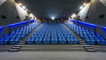 A modern auditorium with tiered seating and blue lighting accents.