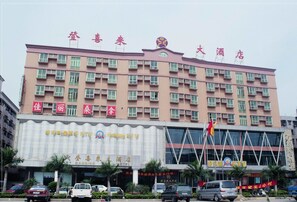 A multi-story hotel with a prominent sign for 'Dancing Hotel' and 'Holiday KTV' on the facade. - Dengxillai Hotel Foshan (Foshan)