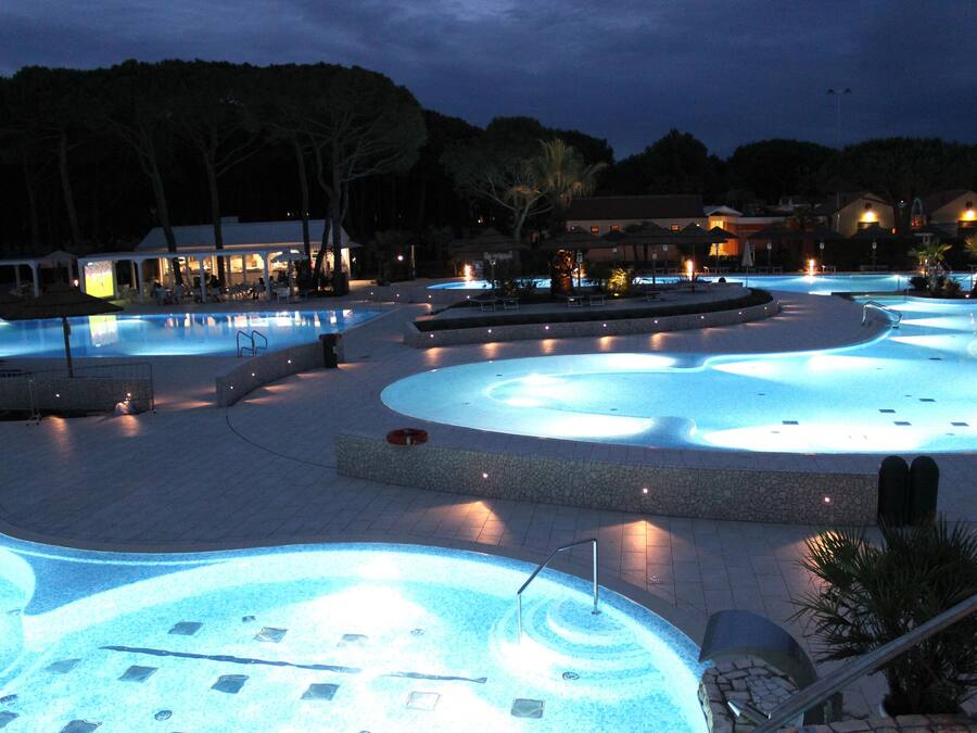 Alberca al aire libre, sombrillas en la alberca y camastros