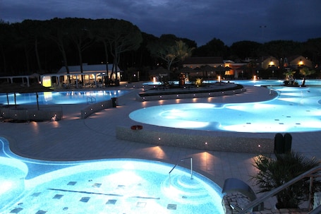 Piscine extérieure, parasols de plage, chaises longues. Ca' Pasquali Village