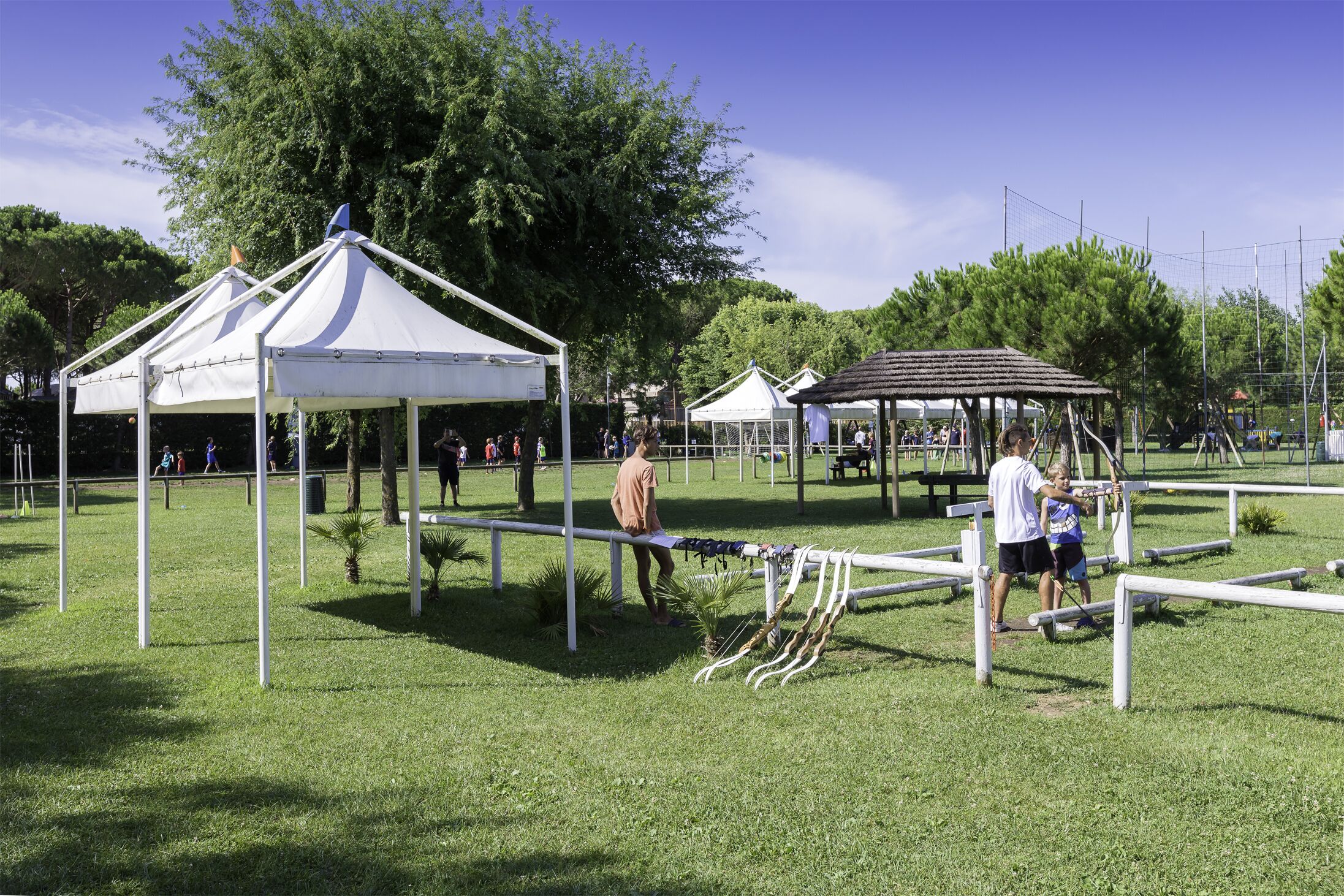 A park with white tents, a playground, and a gazebo.