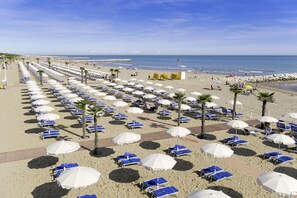 Playa privada, arena blanca, sillas reclinables de playa, sombrillas