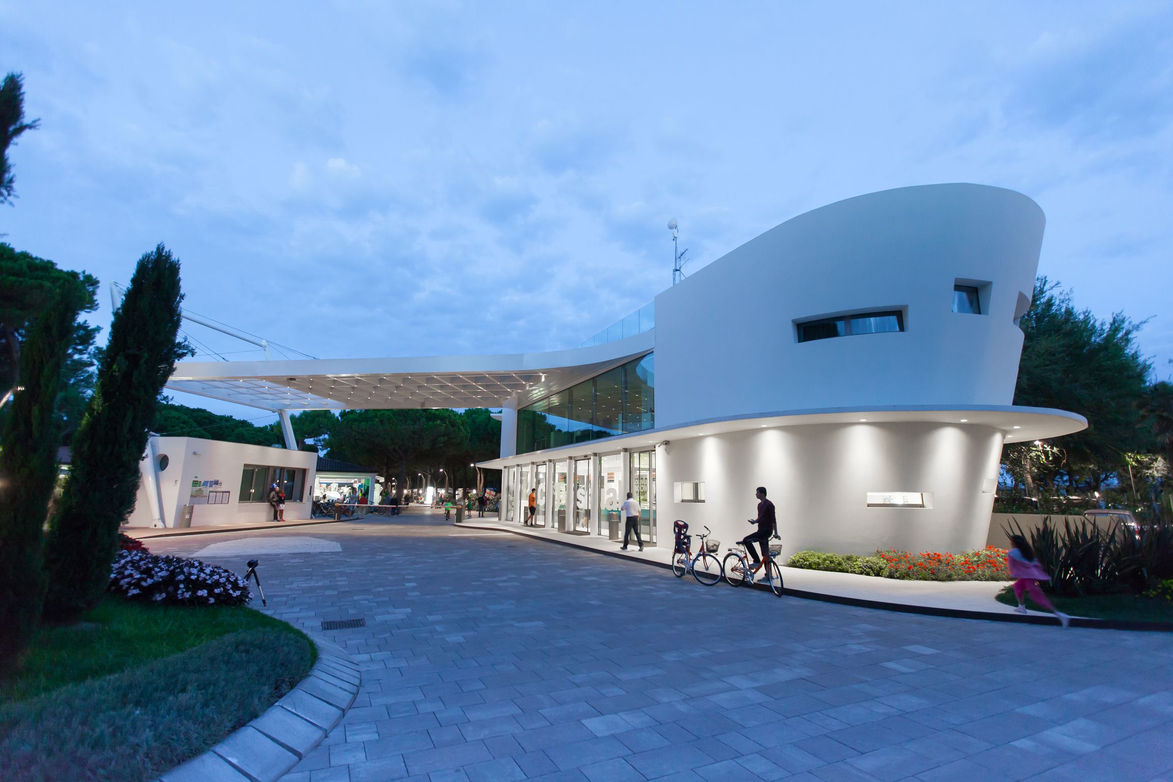 Un bâtiment moderne doté d’une façade incurvée et d’un espace d’entrée abrité.