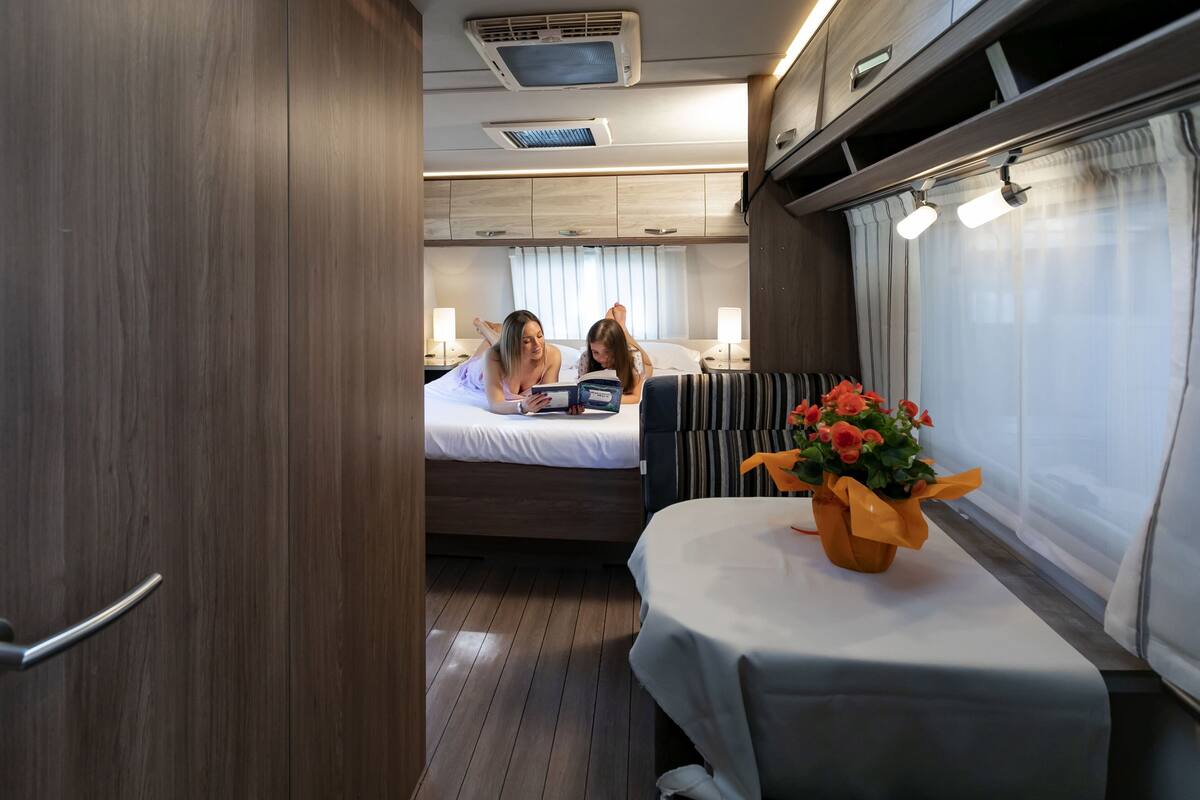 Een knus interieur met een bed, nachtkastjes en een tafeltje met een bloevas.
