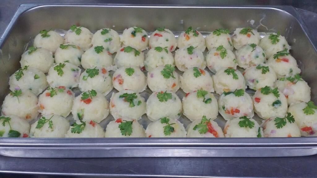 A tray of round, white food items garnished with green herbs.