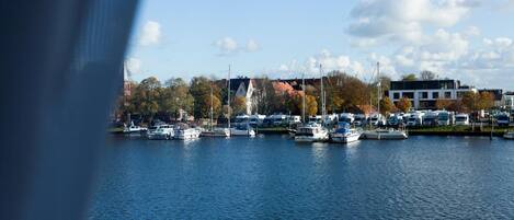 A marina with boats docked, a church, and a modern building.