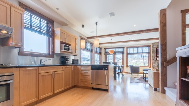 A modern kitchen with wooden cabinets, stainless steel appliances, and large windows. - Yukimi 1 (Kutchan)
