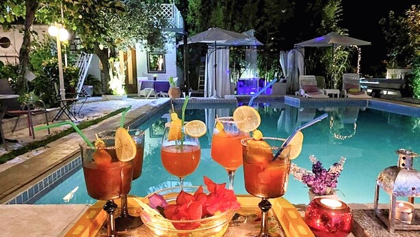Un bar junto a la piscina con bebidas y un frutero.