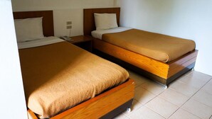 Dos camas individuales con cabeceros de madera y ropa de cama color beige en una habitación de hotel.