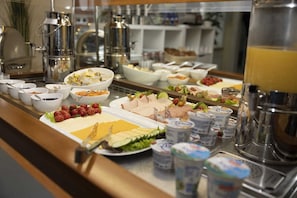 A buffet with various food items and beverages.