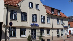 A hotel with a sign reading "HOTEL" above the entrance, a red-tiled roof, and a brick facade. - Hotel Rendsburg (Rendsburg)