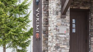 Un edificio con fachada de piedra y puerta de madera con el letrero 