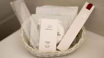 A basket containing cotton swabs and a tissue box.