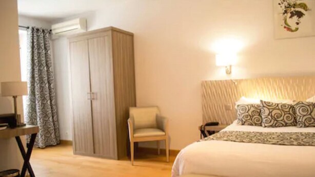 Une chambre à coucher avec un lit, une chaise, un bureau et une armoire.