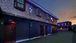 A building with a brick facade, numbered garage doors, and a star-shaped light fixture. - Fukun 3 Motel (Yilan)
