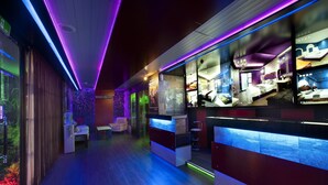 A modern hotel lobby with a reception desk, seating area, and a large digital display showing room options. - Fukun 3 Motel (Yilan)