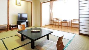 Una habitació tradicional japonesa amb sòls de tatami, una taula baixa i portes corredisses.