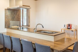 Une cuisine moderne dotée d’un îlot central, d’un évier en acier inoxydable et d’une cuisinière intégrée.