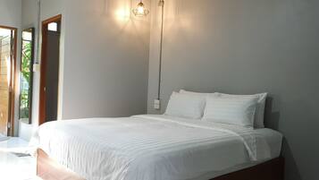 A bedroom with a bed, a nightstand, a wall-mounted lamp, and a door leading to a balcony.