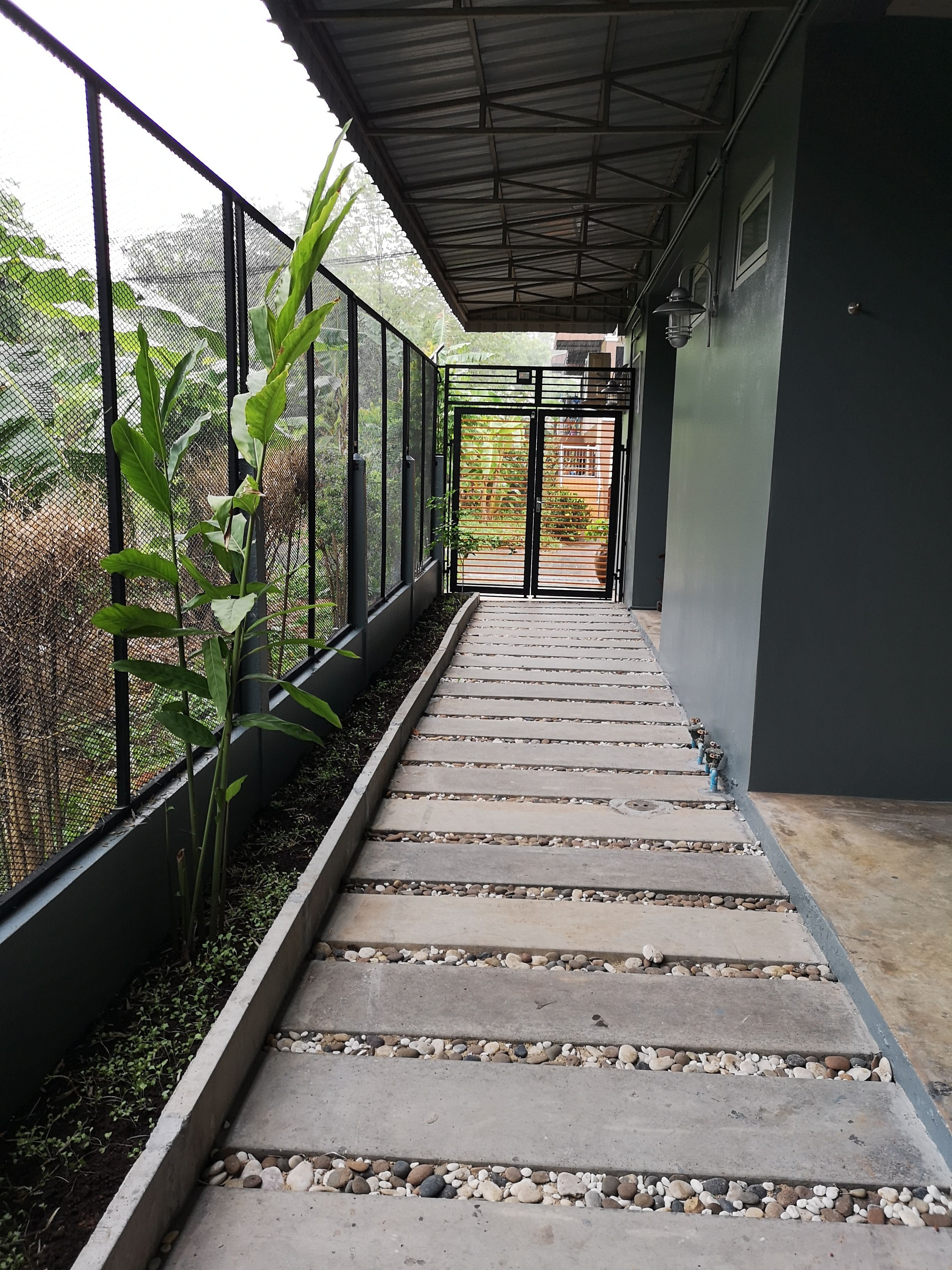 A concrete staircase with stone railings and a metal fence on one side.