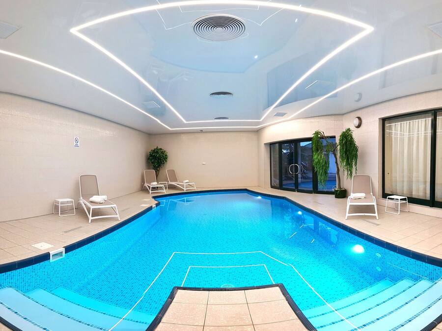 Una piscina techada, sillones reclinables de piscina