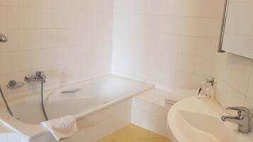 Ein Badezimmer mit einer Badewanne, einer Dusche und einem Waschbecken.