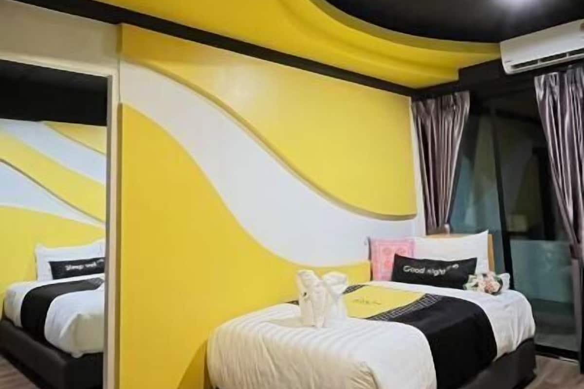 Una habitación de hotel moderna con techo curvo, una cama grande, un espejo y una ventana con cortinas.