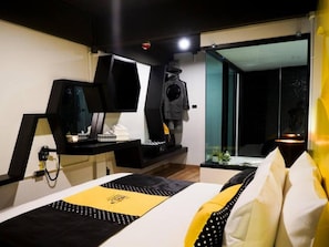 Une chambre d’hôtel moderne équipée d’un lit, d’un bureau, d’une télévision et offrant une vue sur l’extérieur.