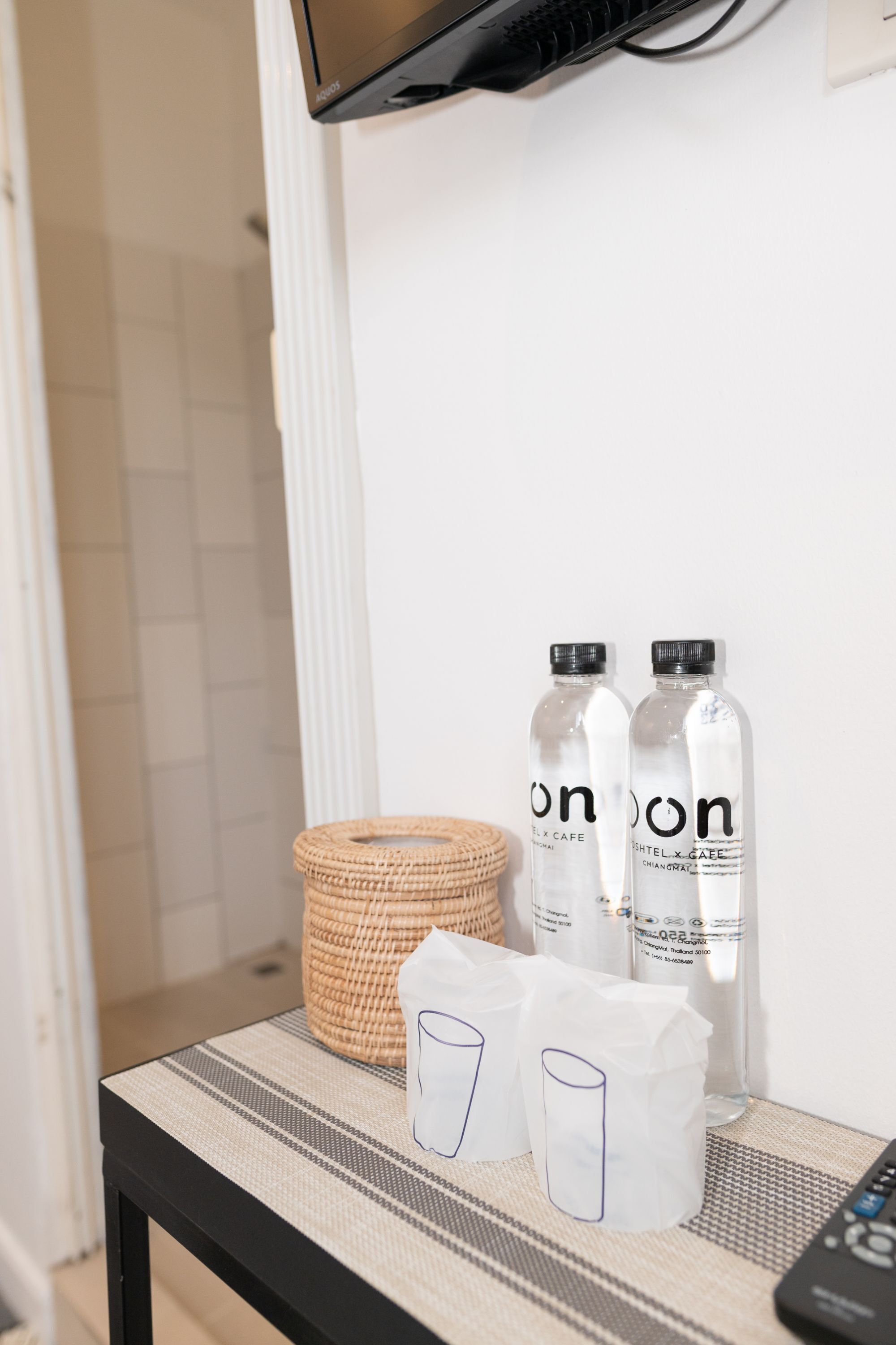 A table with two bottles of Onion water, a woven basket, and two tissue boxes.
