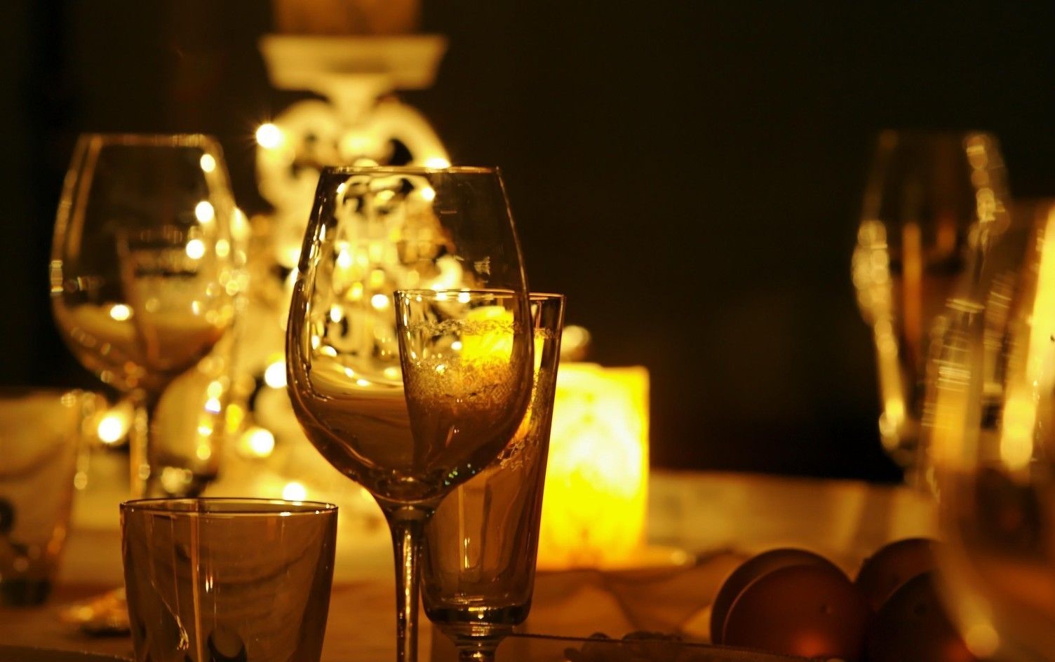 A table set with wine glasses and a candle, suggesting a dining or social setting.