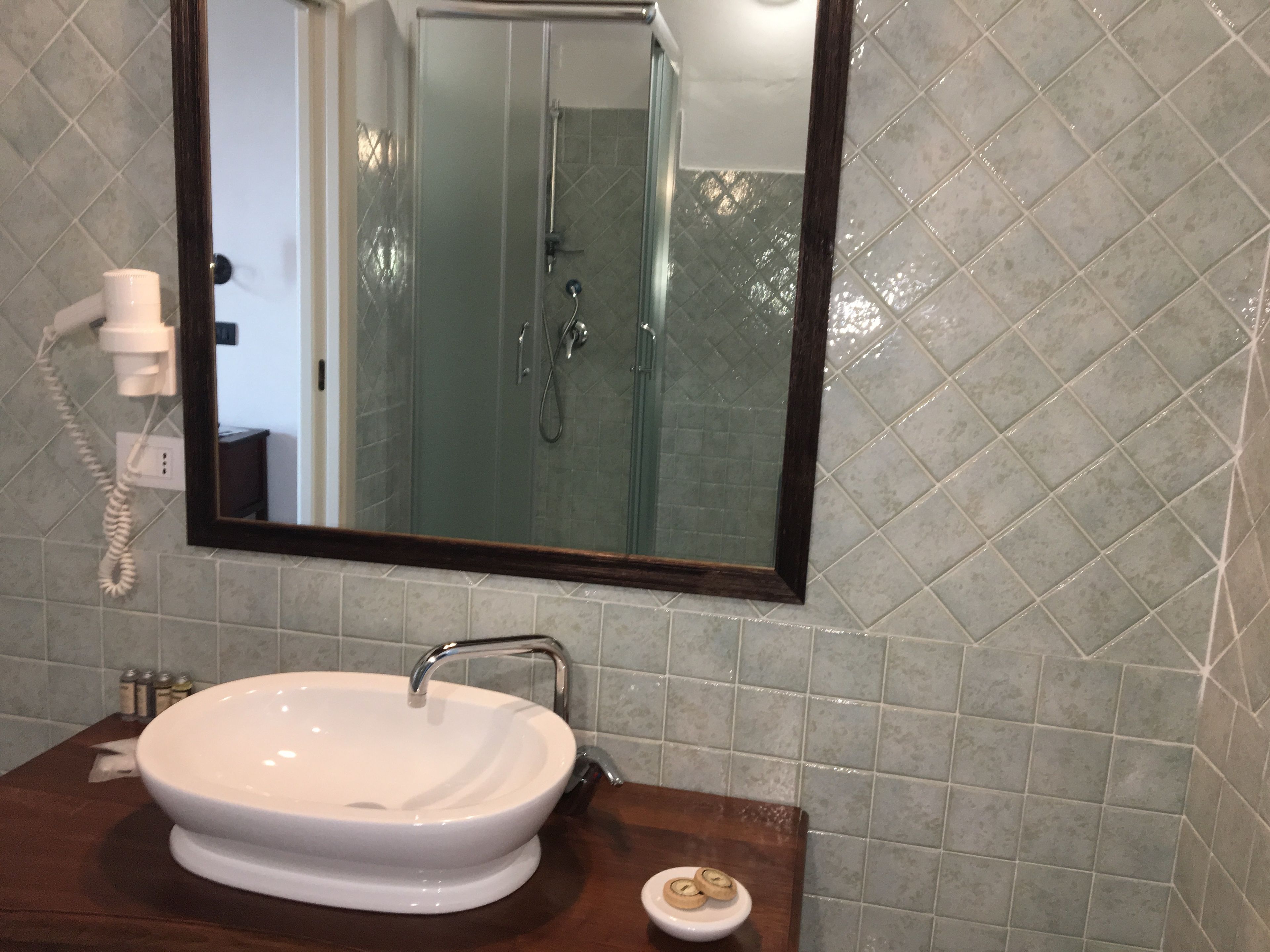 A bathroom with a white sink, a mirror, and a shower area.