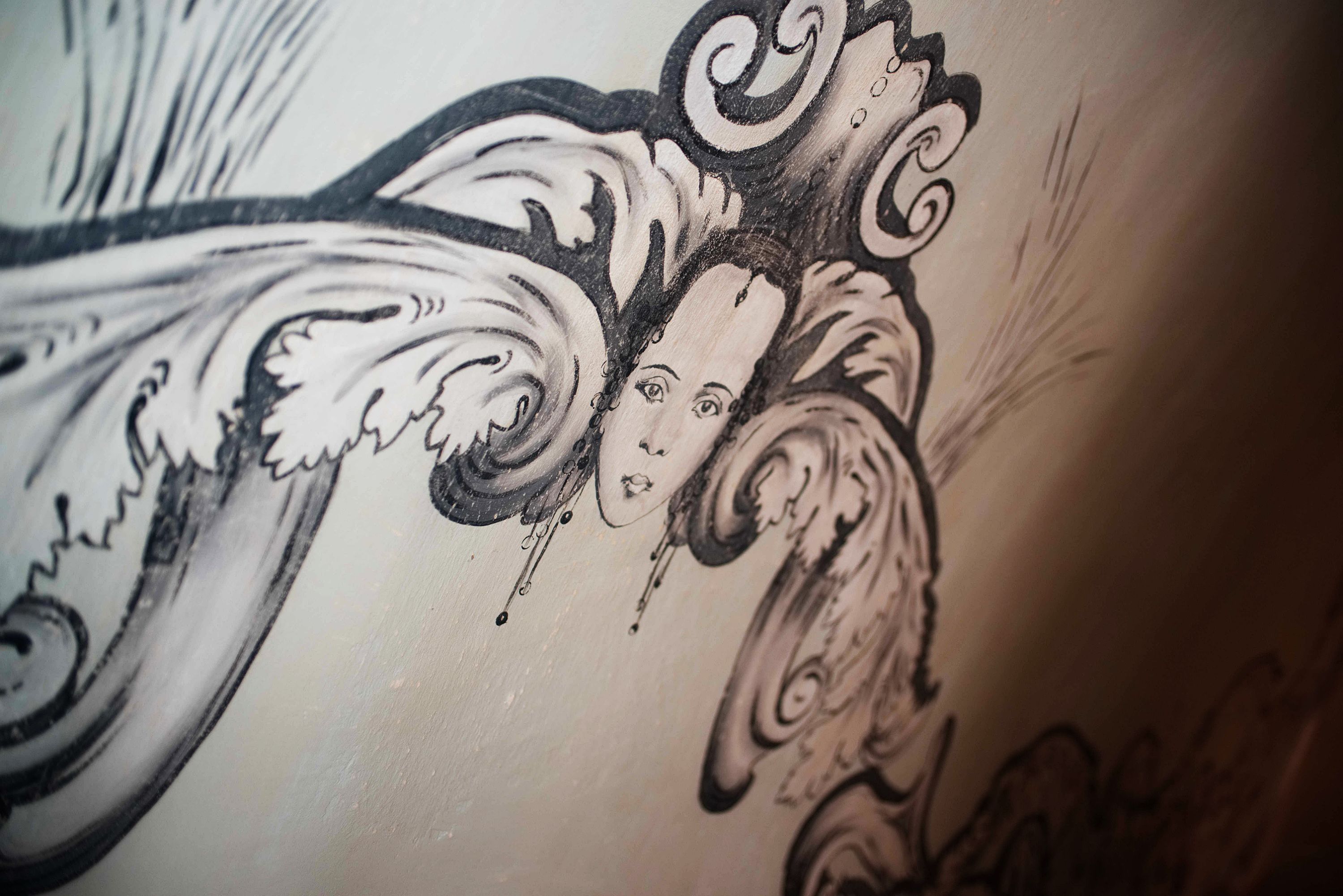 Een gedetailleerd zwart-wit tatoeage ontwerp op een muur.