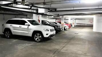 A parking garage with multiple cars parked in rows.