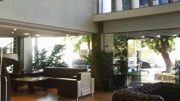 Un vestíbulo espacioso con un sofá, una mesa de centro y un ventanal con vistas al exterior.