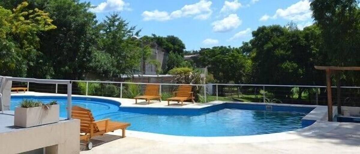Una piscina al aire libre, sombrillas, tumbonas