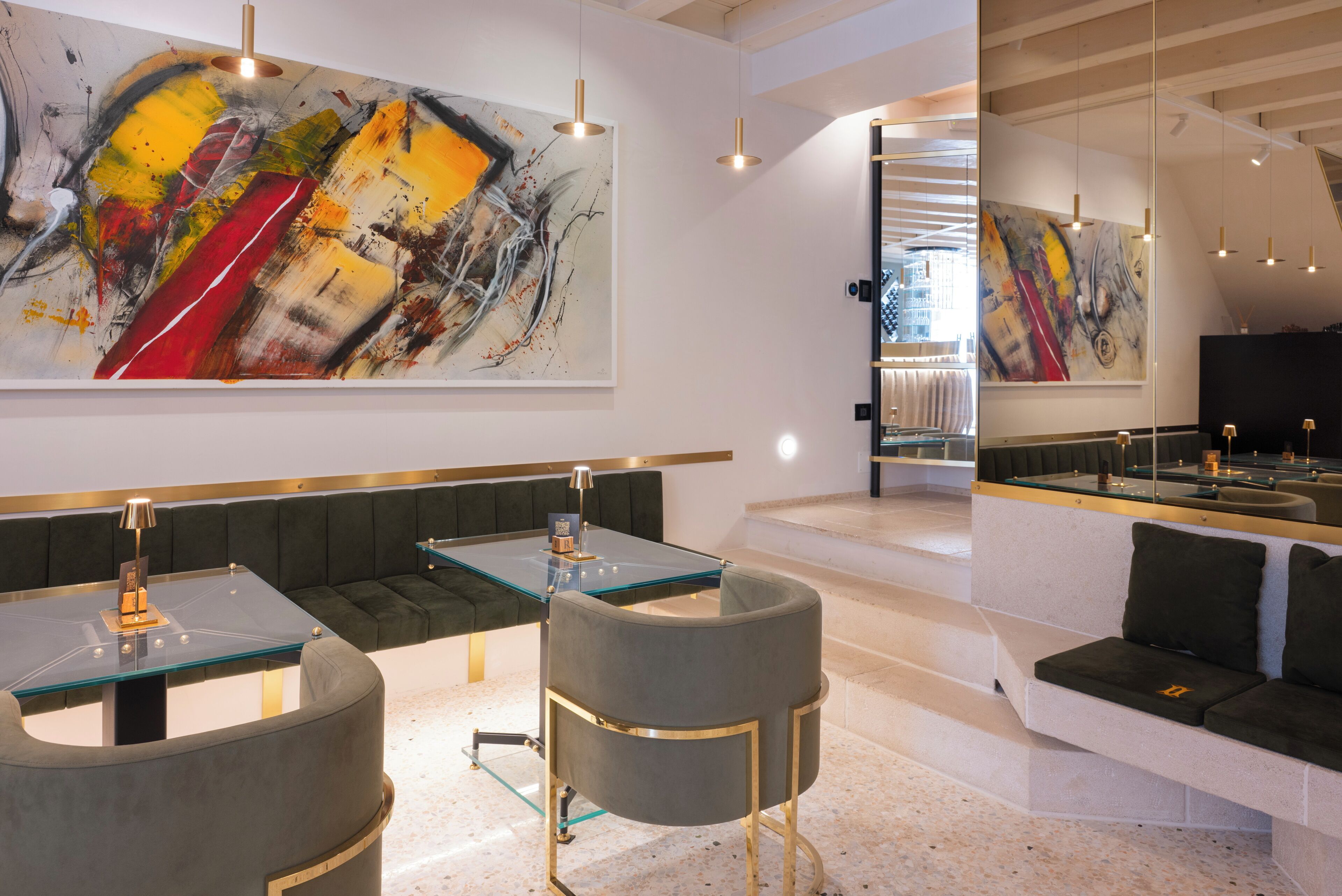 A modern interior with a glass-top table, a sofa, and abstract art on the walls.