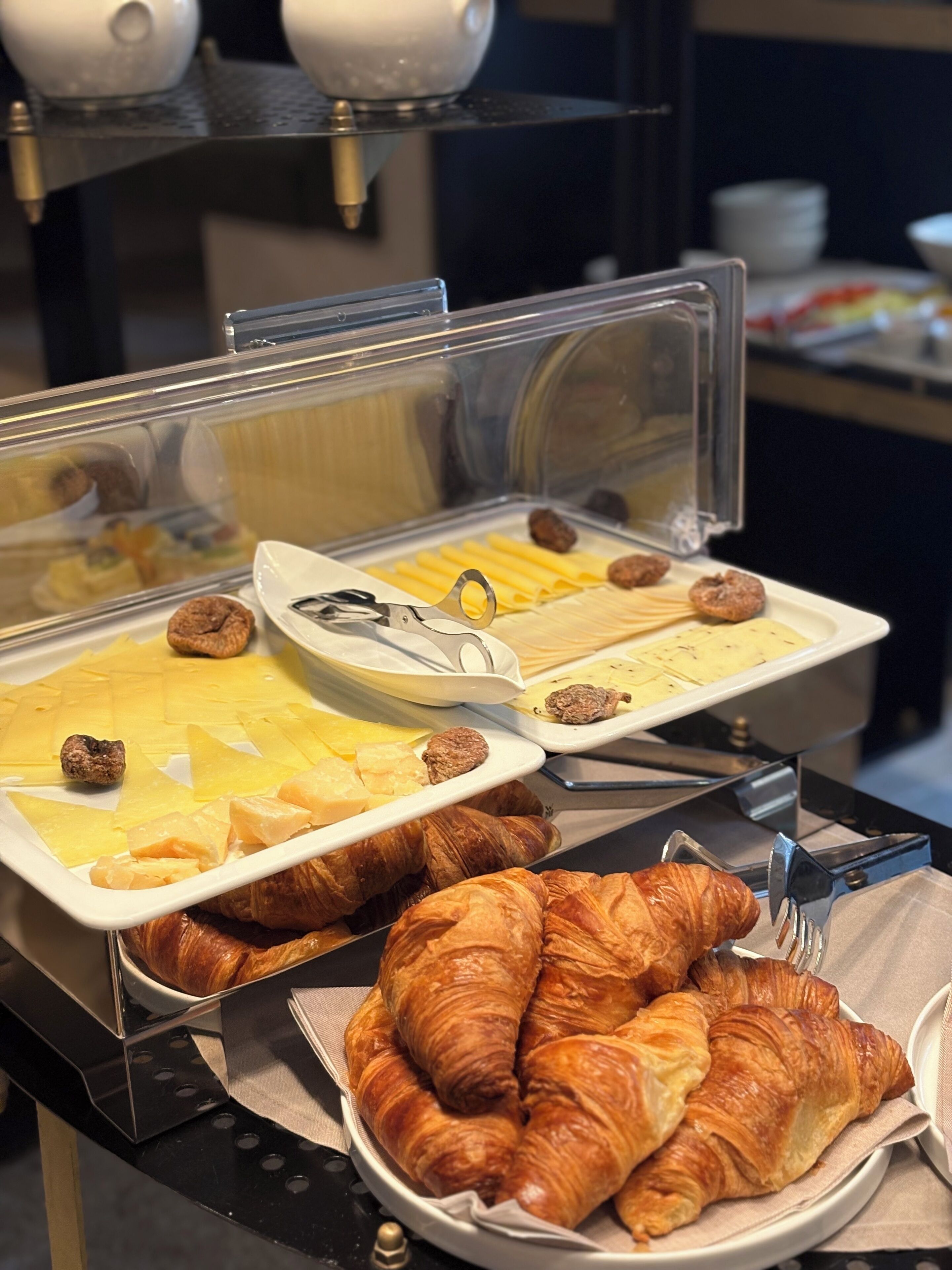 Un buffet proposant une variété de plats, notamment des pâtisseries, des fruits et une assiette de croissants.